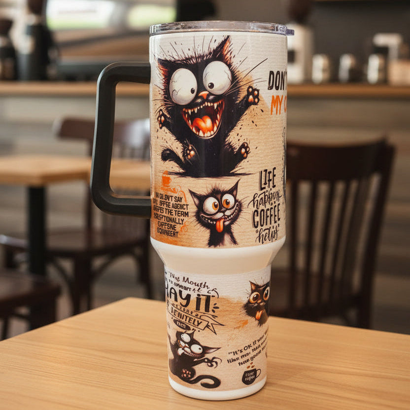 Tumbler with cartoon cat design and text on a wooden surface