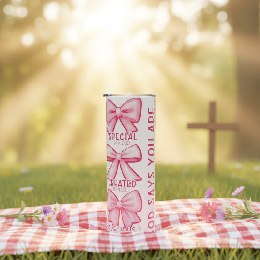 Tumbler with pink bows and text on a white background