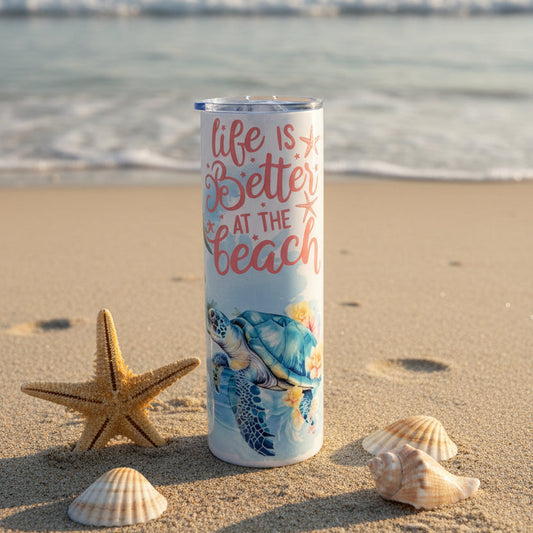 Tumbler with a beach-themed design featuring a turtle and text 'Life is better at the beach' on a black textured surface.