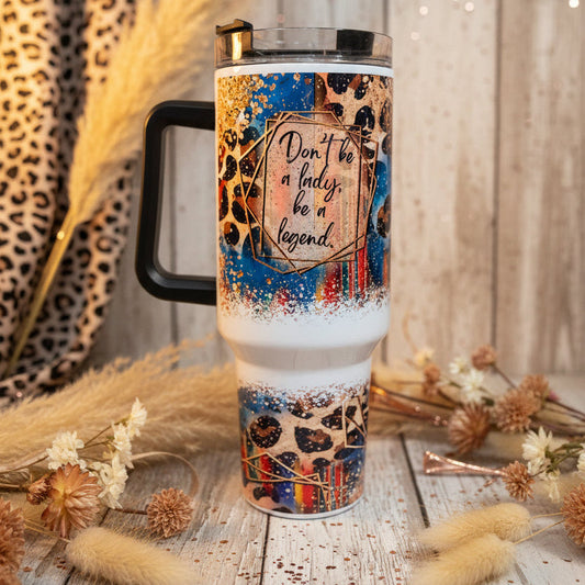 Tumbler with decorative sleeve and motivational quote on a countertop.