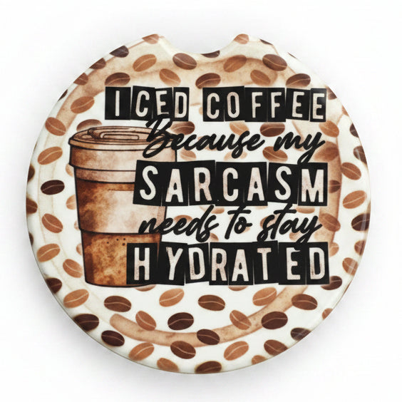 Car coaster with coffee-themed design and text in a clear package on a wooden surface