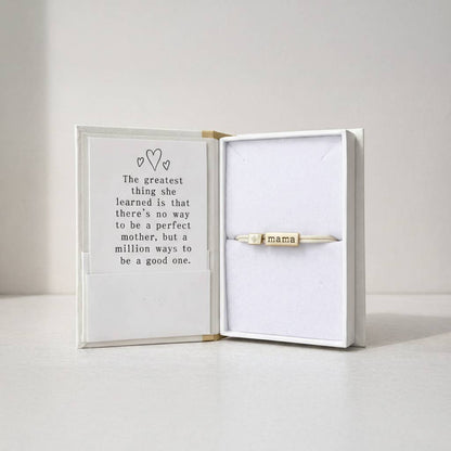 Gold 'mama' necklace in a box with a quote about motherhood.